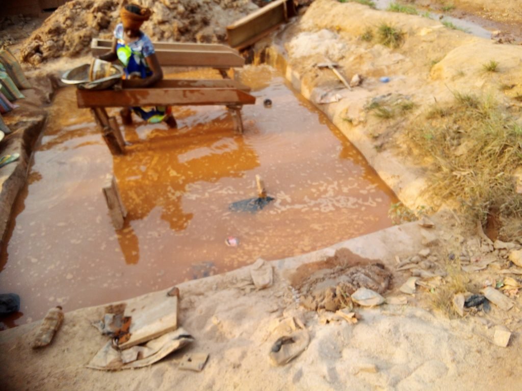 Artisanal miner in the washing process in search of gold from the leftover soils of semi mechanised companies in Kamnelle II